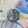 Angel holding shark button badge pin