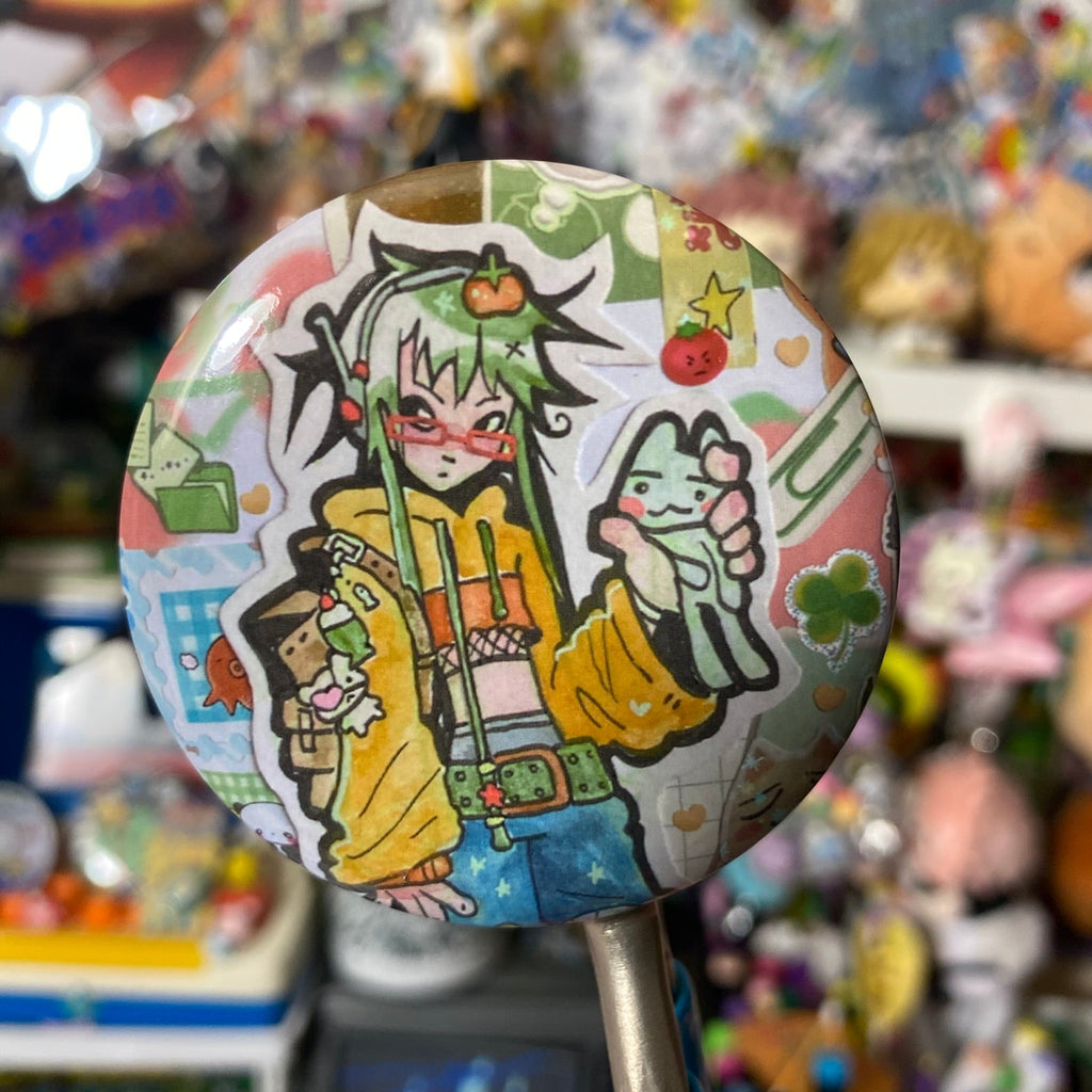 shiny round button badge with character with green hair and many trinkets on their bag