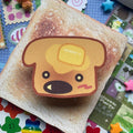 Brown dog head shape sticker in toast shape with melting butter, shiny black nose and glitter finish