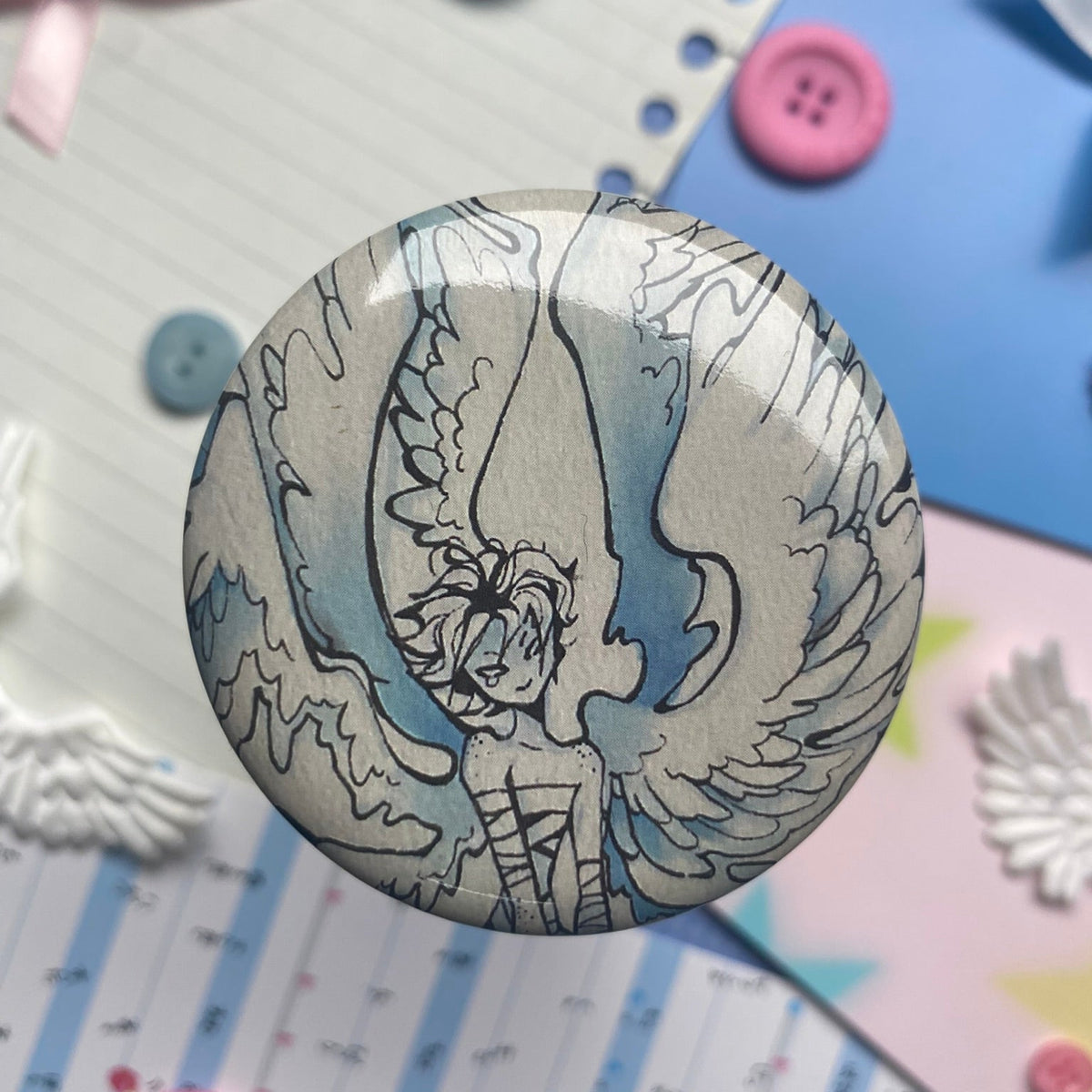 shiny round button badge with head shot of Winged pilot and wings